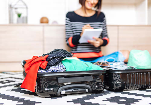 eautiful,Young,Woman,Packing,Her,Stuff,Into,A,Big,Suitcase.