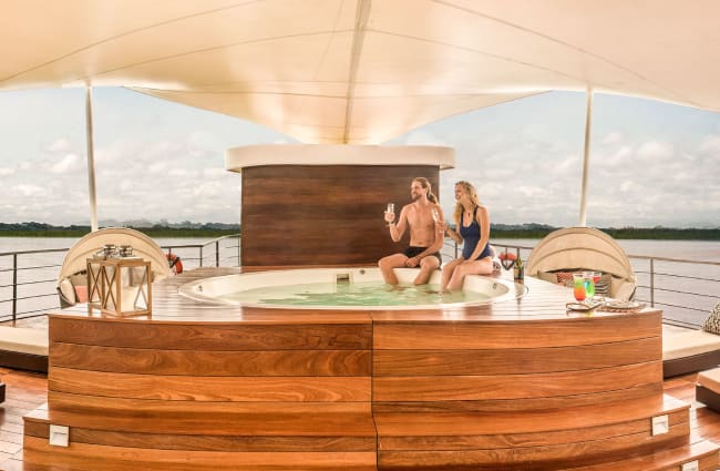 A couple in a jacuzzi on the cud deck